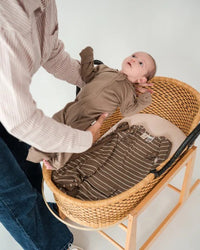 Baby wearing the Babu 3 Season Merino Sleeping Bag made from soft 100% extrafine merino wool for cosy and breathable sleep comfort.