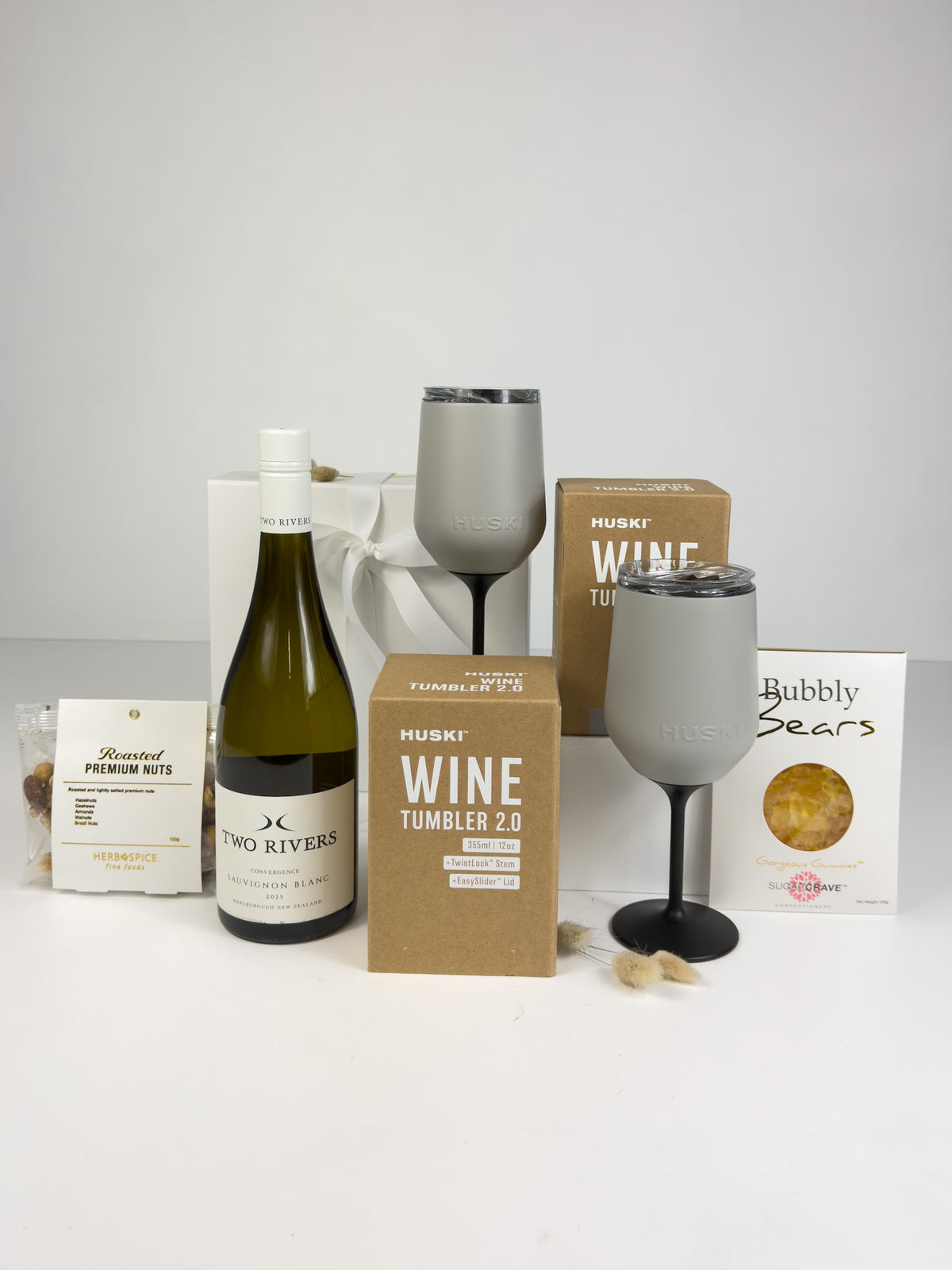 Luxury wine and treats gift box for couples featuring a premium bottle of wine, two Huski wine tumblers, bubbly gummy bears and gourmet nuts, perfect for weddings, engagements and anniversaries.