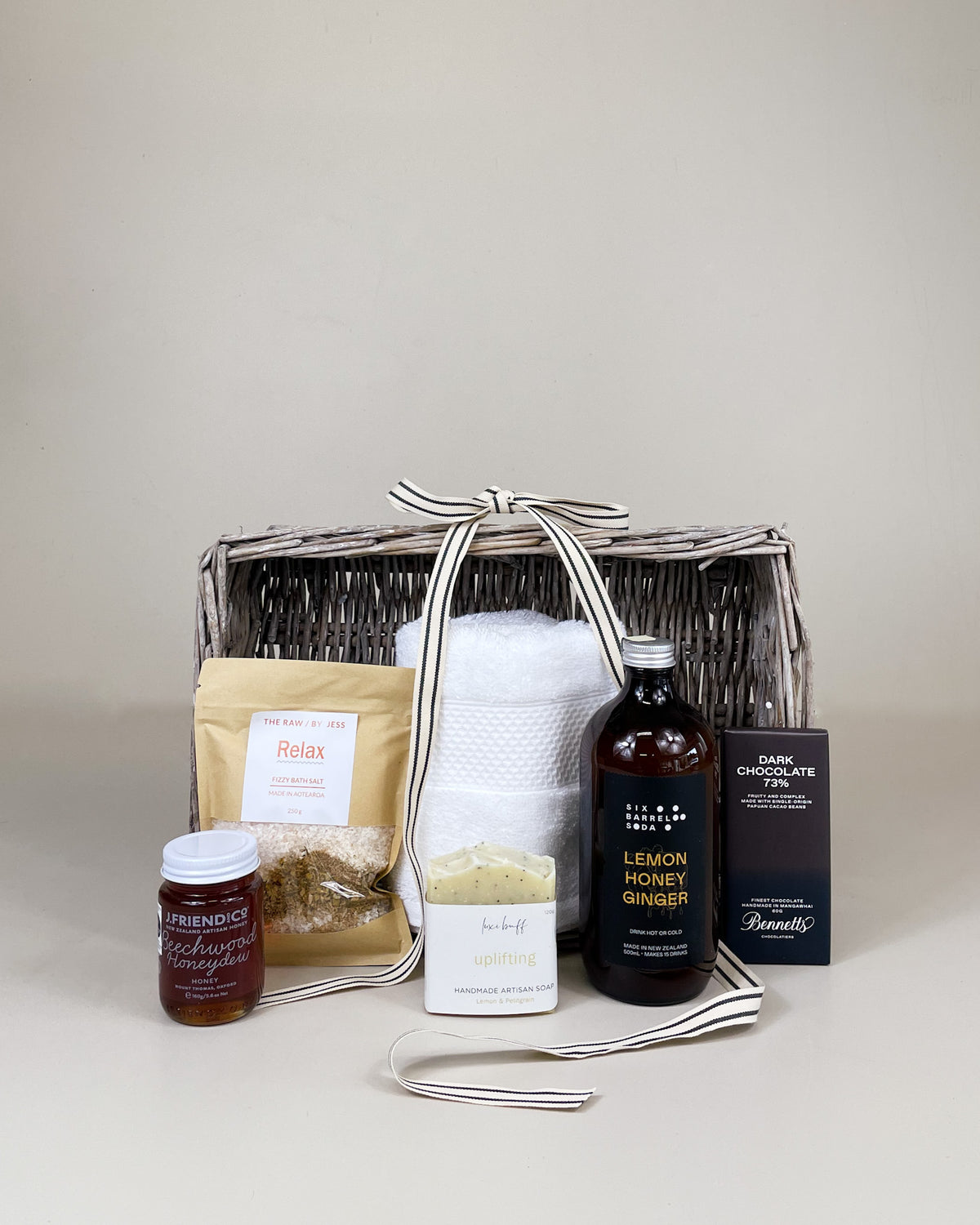 Comfort Care Gift Basket featuring lemon and honey syrup, relaxing bath salts, natural honey ,organic soap, and dark chocolate in a beautifully presented gift box.