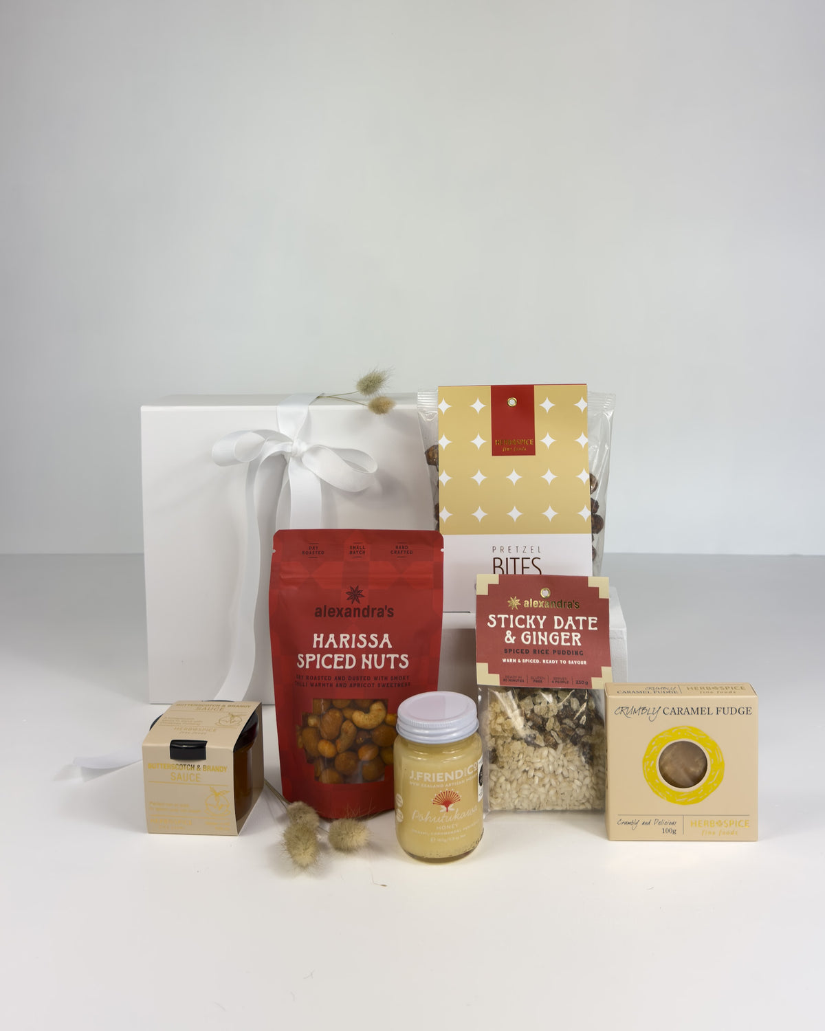 Festive Christmas gift box with spiced nuts, pretzels, butterscotch sauce, honey and sticky date pudding