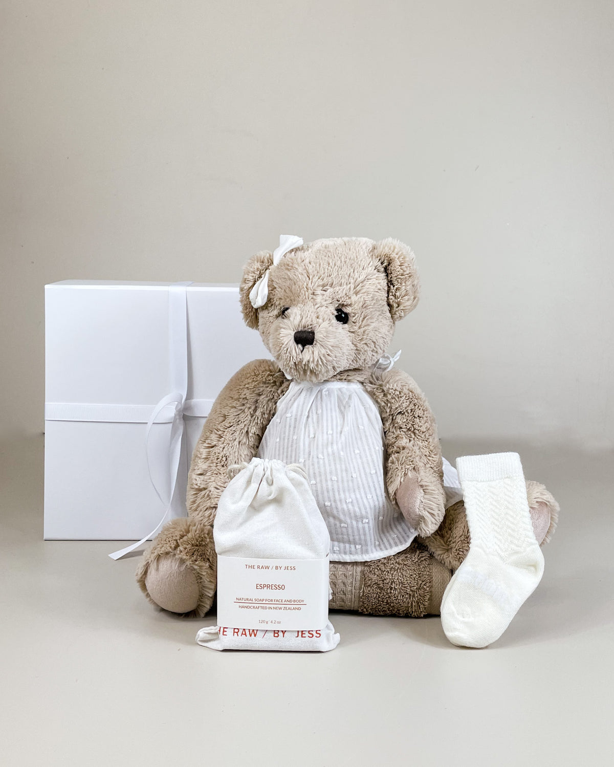 Newborn baby girl gift box with fluffy teddy, merino socks, and natural soap for mum. Thoughtful NZ newborn gift box.