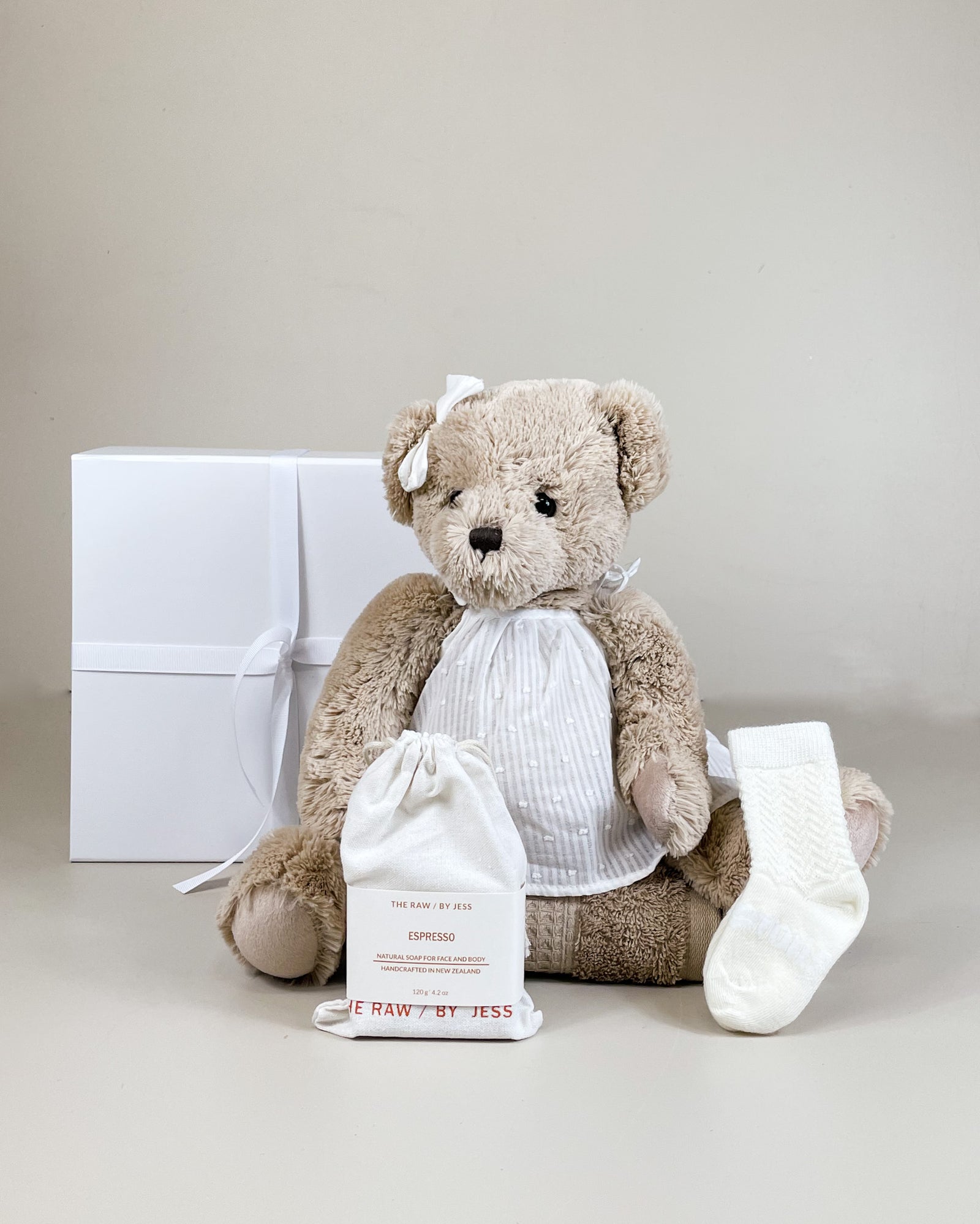 Newborn baby girl gift box with fluffy teddy, merino socks, and natural soap for mum. Thoughtful NZ newborn gift box.