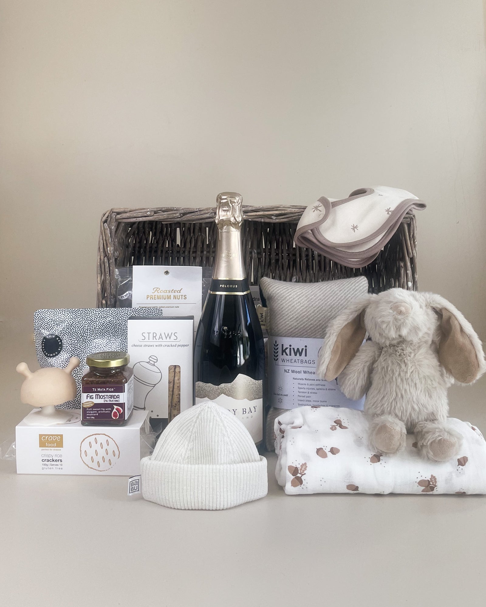 Luxury Baby Gift Basket NZ with artisan food, sparkling wine, merino baby swaddle, and NZ wool wheat bag for new parents
