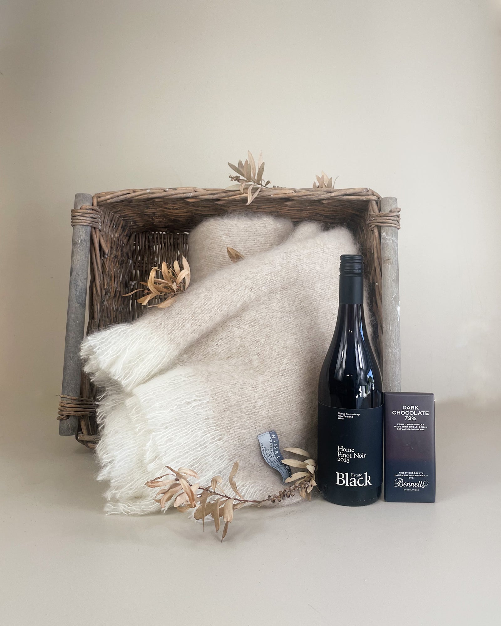 Luxury New Zealand gift basket with mohair throw, dark chocolate, body lotion, and wine elegantly presented in keepsake packaging