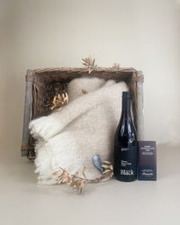 Luxury New Zealand gift basket with mohair throw, dark chocolate, body lotion, and wine elegantly presented in keepsake packaging