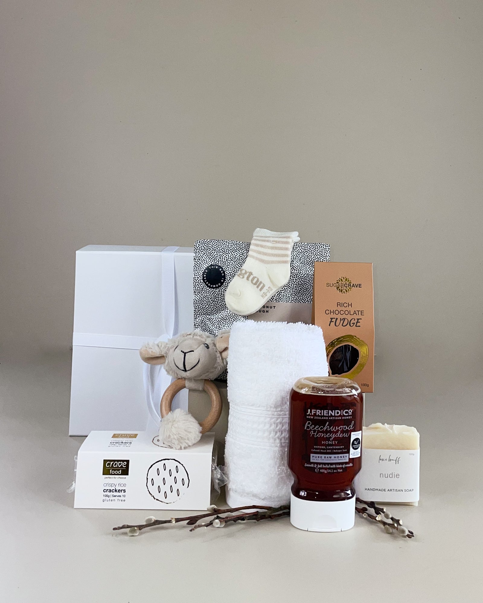 NZ artisan newborn gift box with merino wool, baby socks, wooden teether, honey, soap, fudge and chocolate for baby and parents gift hamper.