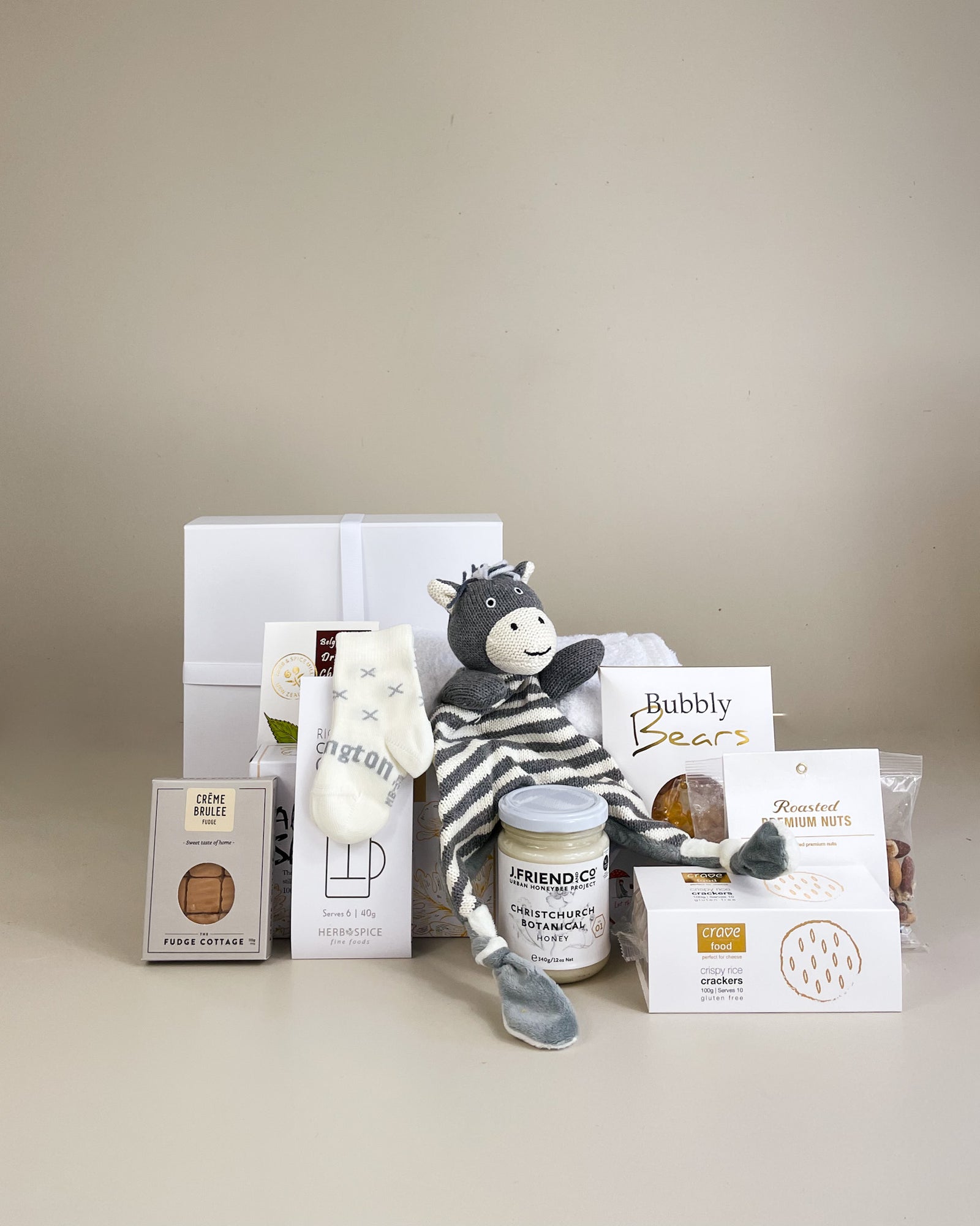 NZ artisan newborn gift box with soft baby socks, Zebra comforter, NZ honey and sweet fudge, beautifully presented for new baby and parents.