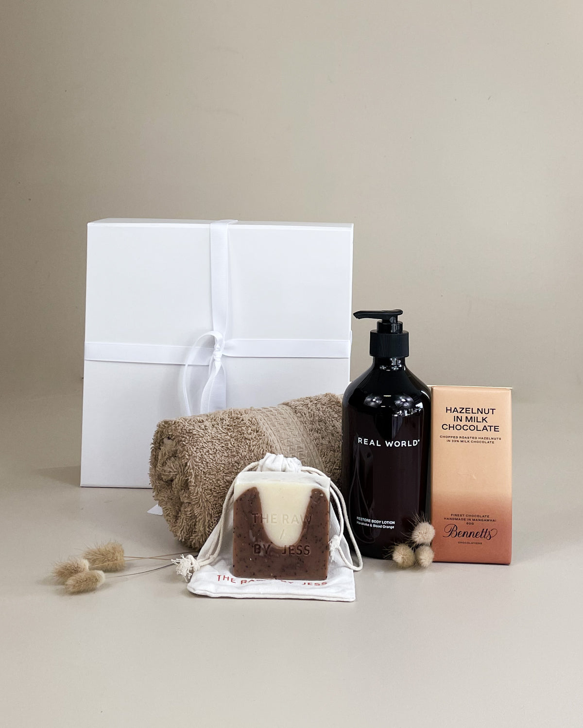 Pamper Gift Box featuring NZ-made body lotion and sweet chocolate treats in elegant gift packaging.