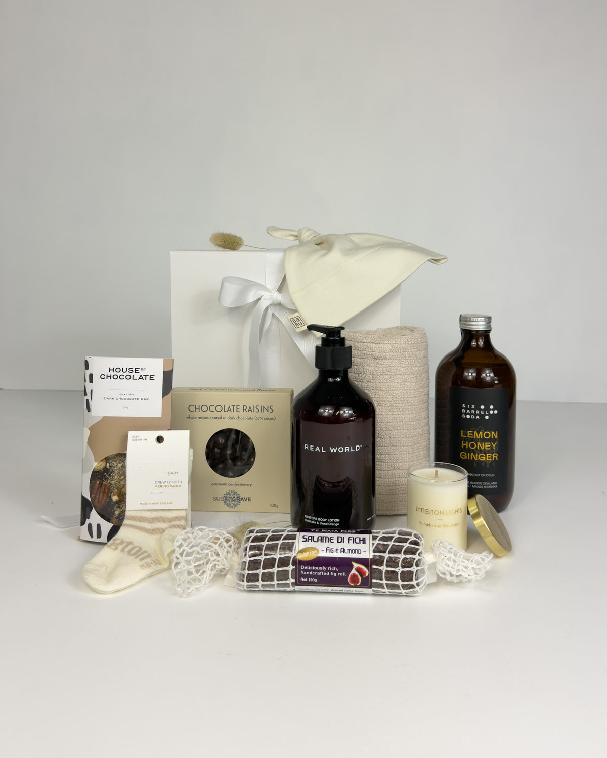 Precious newborn baby gift box with Merino newborn socks, Natural Knot beanie and a treat for new mum, beautifully presented in New Zealand