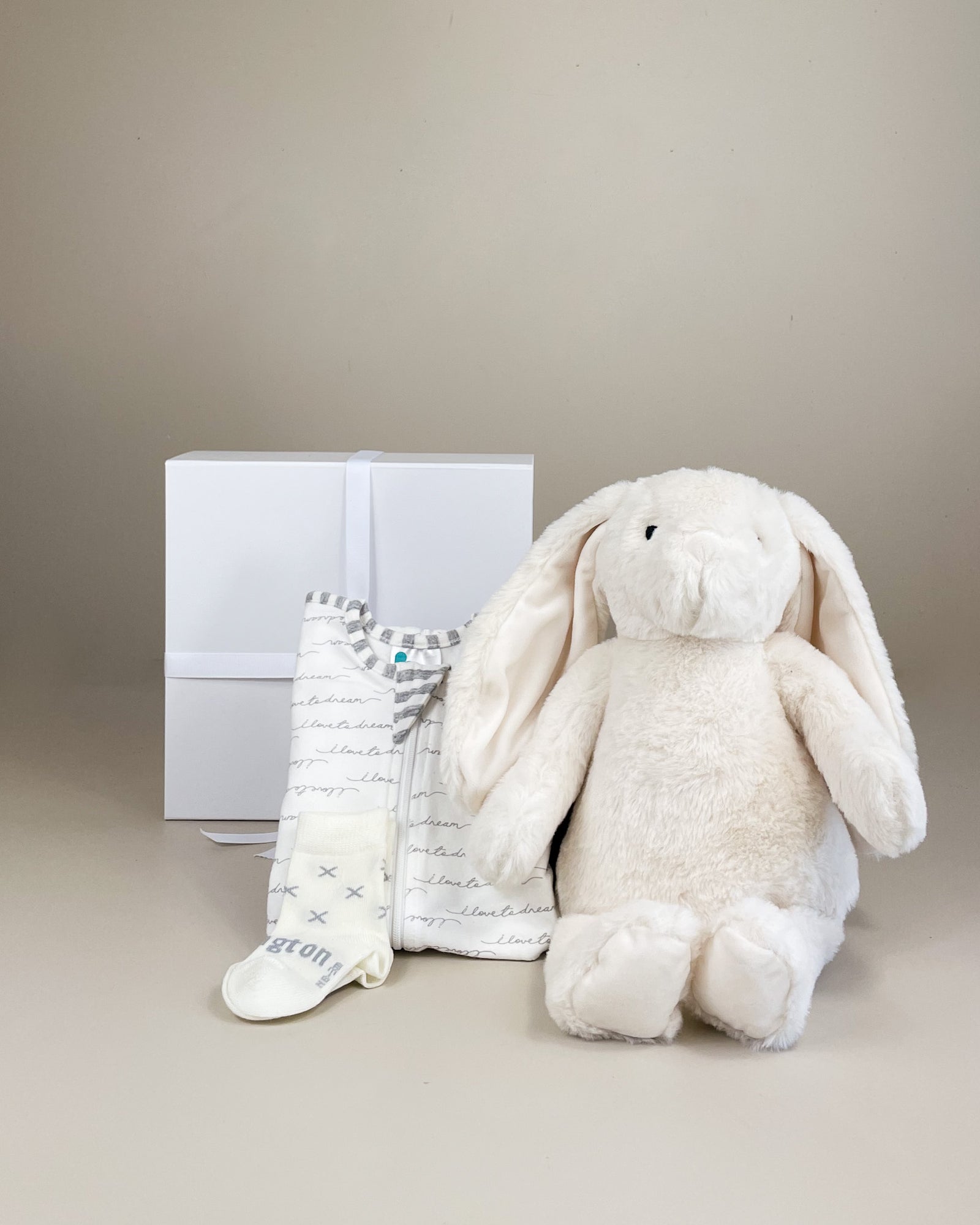 Precious newborn gift box with keepsake teddy or bunny, Love To Dream swaddle and NZ merino socks for a thoughtful baby gift delivered across New Zealand.