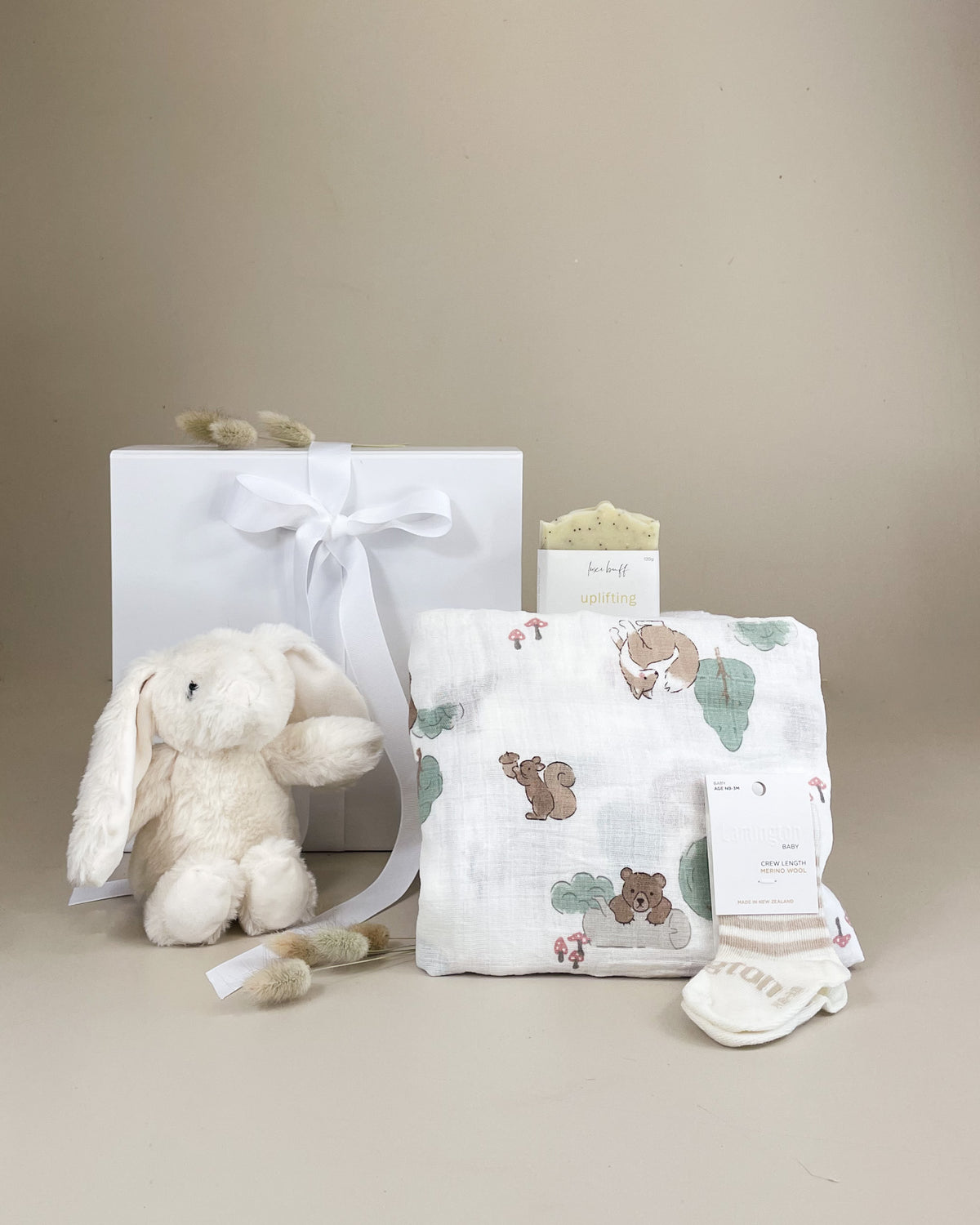 Welcome Baby Gift Box with soft merino socks, cosy muslin wrap and fluffy bunny for newborn baby girls or boys.