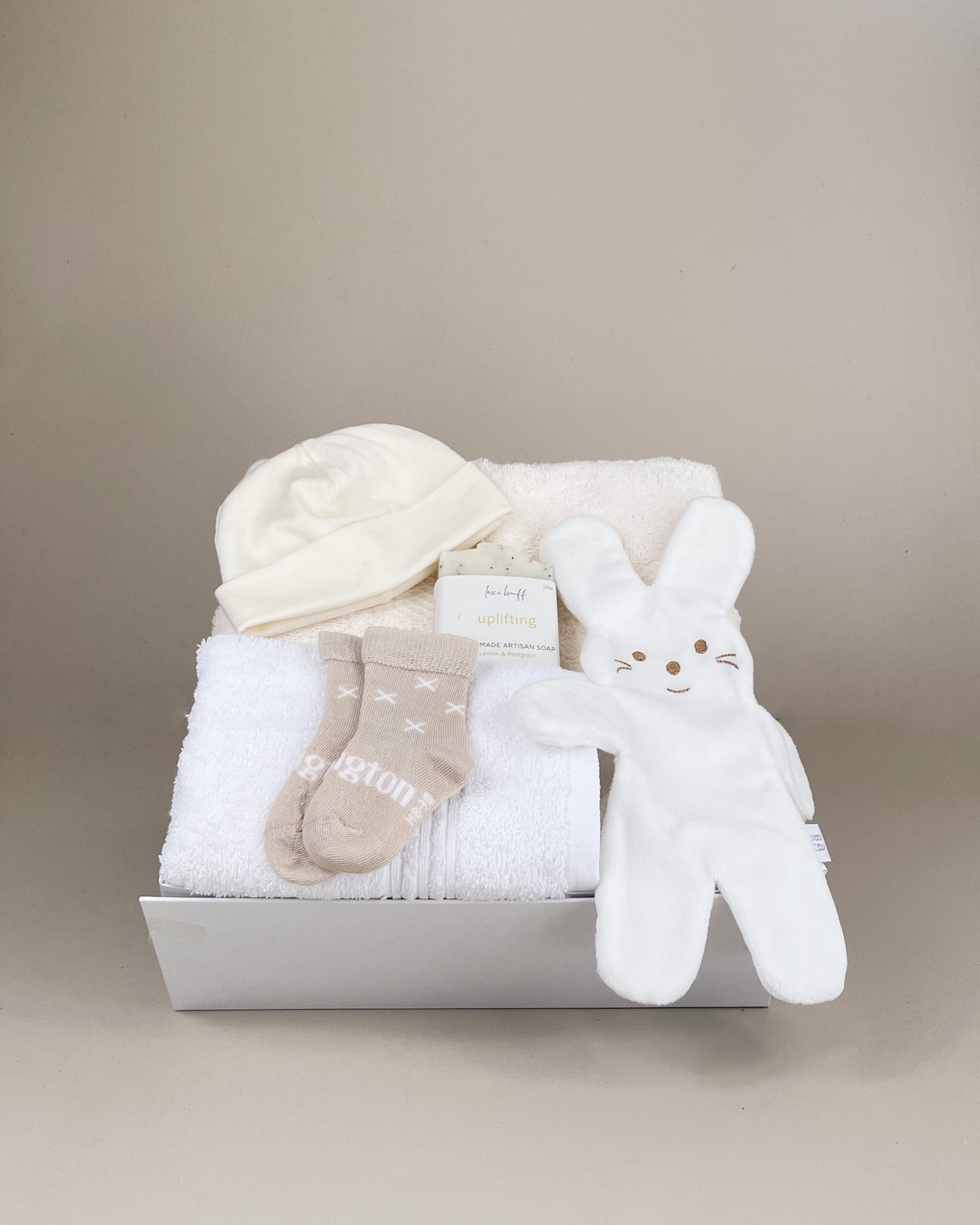 Welcome Little One Baby Gift Box with soft bunny comforter, merino newborn beanie and cosy merino baby socks, beautifully presented in a premium white gift box with ribbon.